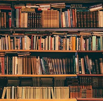 An image of old books stacked on shelves. 