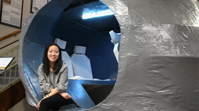 Student Hien Ngo sits inside her model Mars rover.