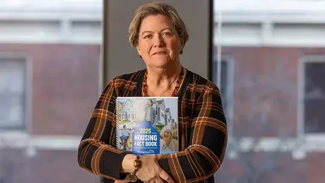 Brenda Clement holds a copy of the 2025 Housing Fact Book.