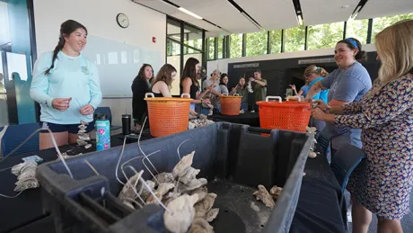 Members of the RWU community take part in an experiential learning opportunity with the Oysters Boys Conservation, a nonprofit that seeks to clean up ocean waters using natural filtration methods.