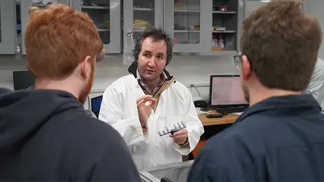 Ahmet Akosman speaks with students in the RWU laser lab.
