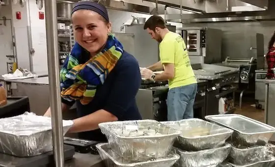 Students in kitchen packing food to donate
