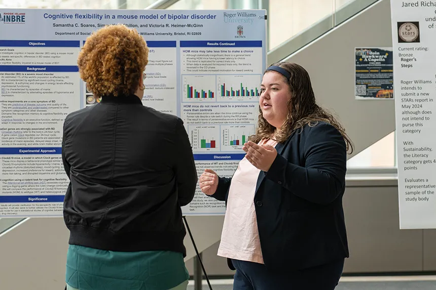A student talks with a professor about her research at SASH.