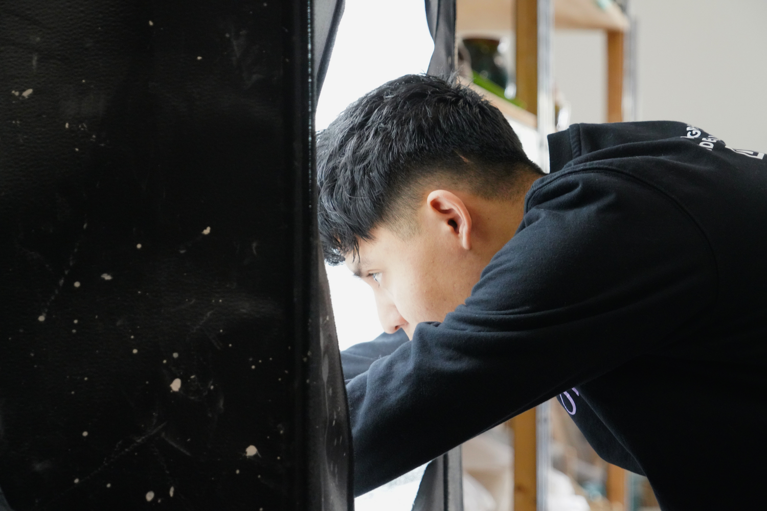 Wilder, a partner in JW Studios, carefully places one of Leonti’s finished works inside a light box.
