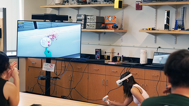 A student wears a VR headset and participates in a VR bloodspatter exercise