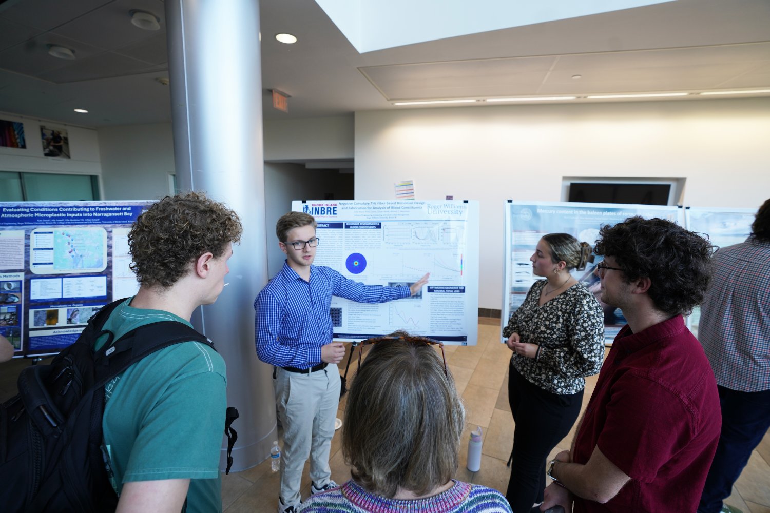 Junior Ethan Neidt, senior Julia Ward, and junior Riley Como showcase their project on advancing breast cancer detection.