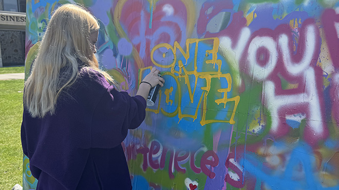 A student paints the Unity Mural 