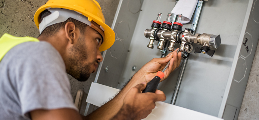 A plumber working on a valve