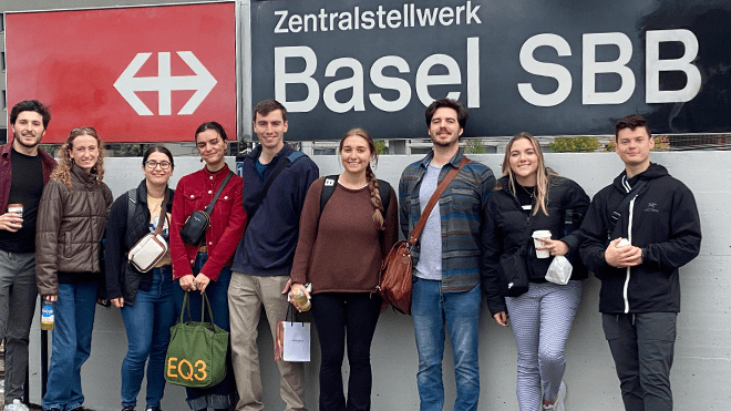 RWU Architecture students stand by a Basel SBB sign during their trip