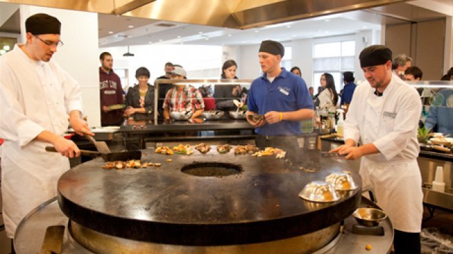 Chefs prepare food in dining hall