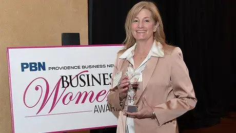 Laura Baldwin holds an award.
