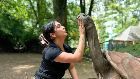 Victoria “Tori” Stephenson ’18 gently pets the neck of a large turtle.