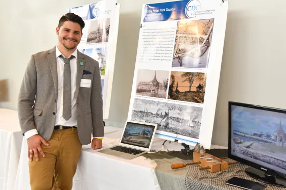 Historic Preservation student stands with his community project at the Community Engagement Celebration
