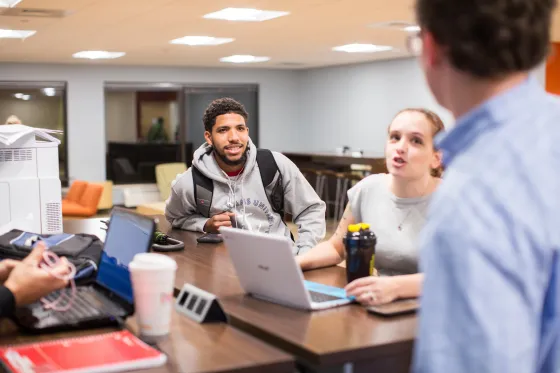 Student smiling at a table