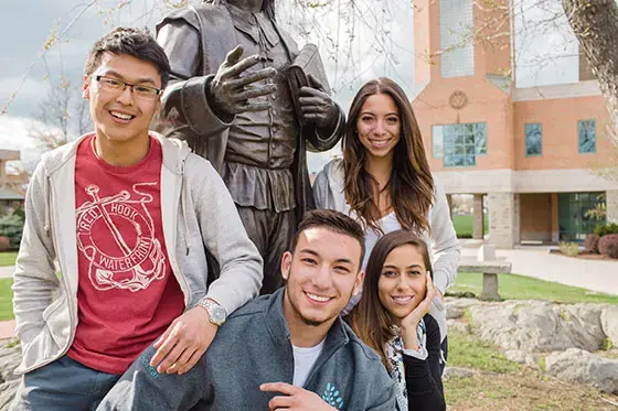 Students gathered around Roger statue.