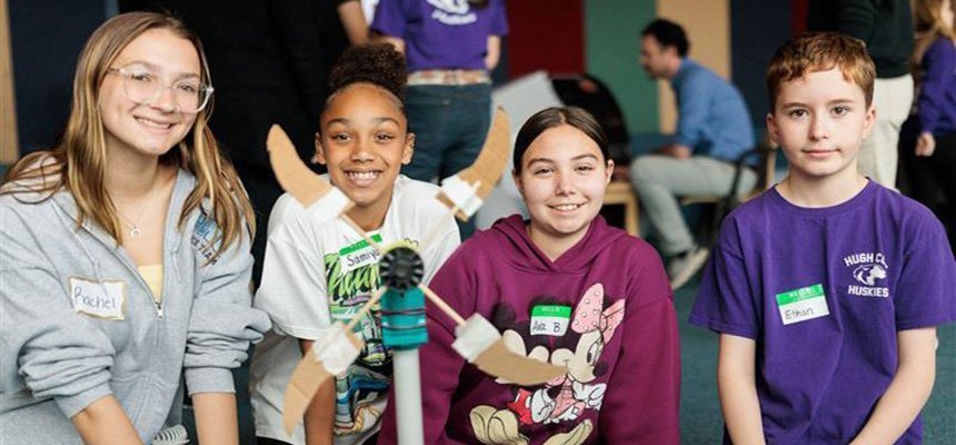 Elementary students pose with a wind turbine that they built
