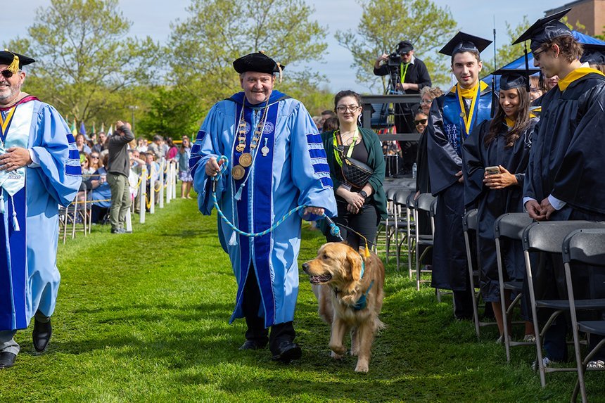 President Miaoulis walks in with his dog Roger