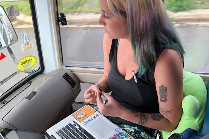 A person on a laptop on a bus