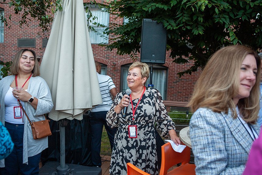 A leader from CVS Health holding a microphone and addressing a group of people outside