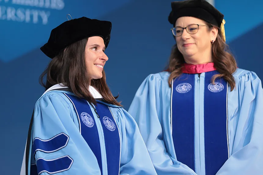 Professors stand on stage