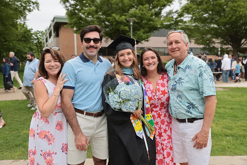An RWU gradate poses for a photo with family