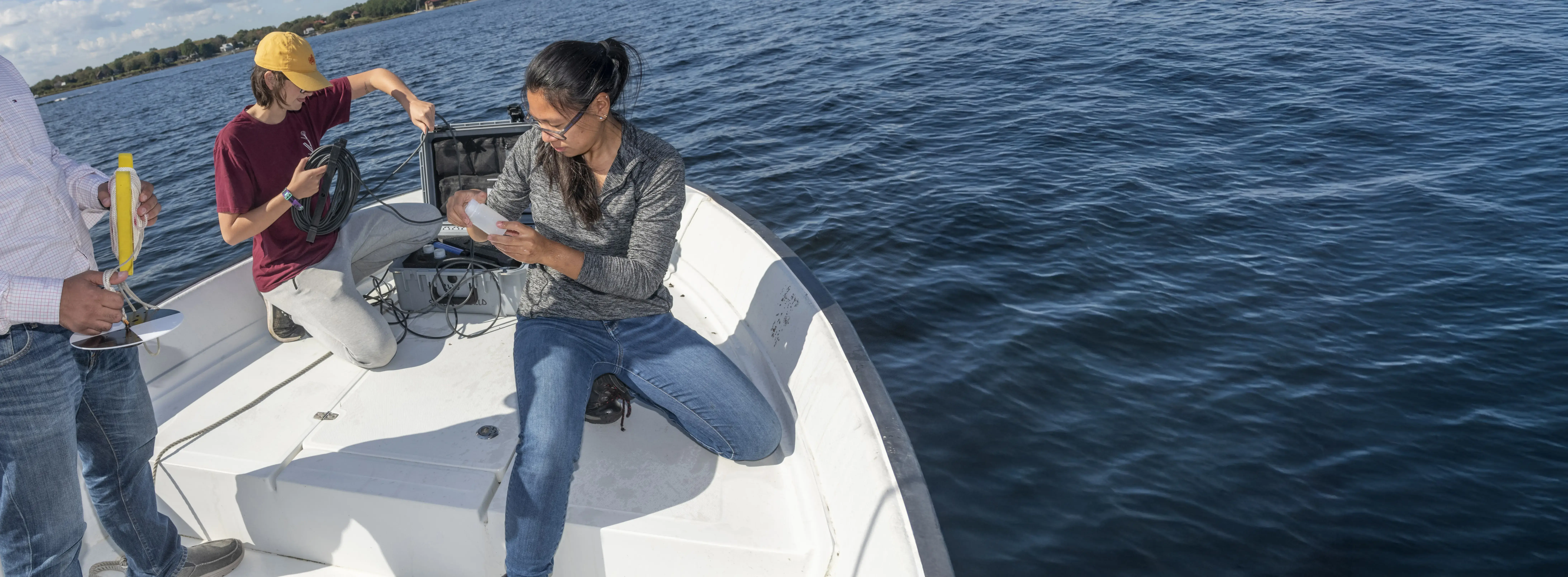 Researchers set up instruments on a small boat, collecting data on the environment.
