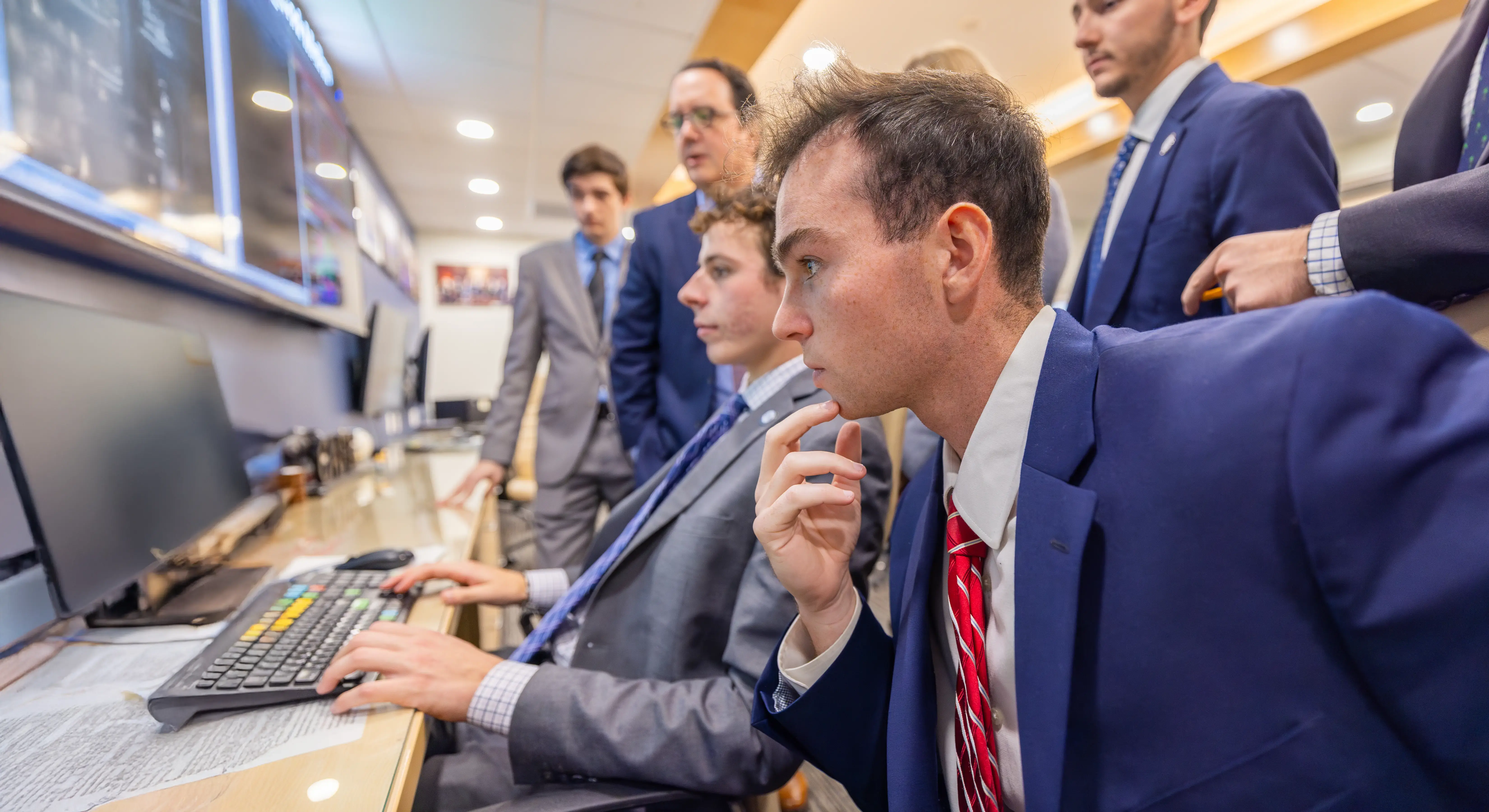 Business students study the market in real time, wearing suits