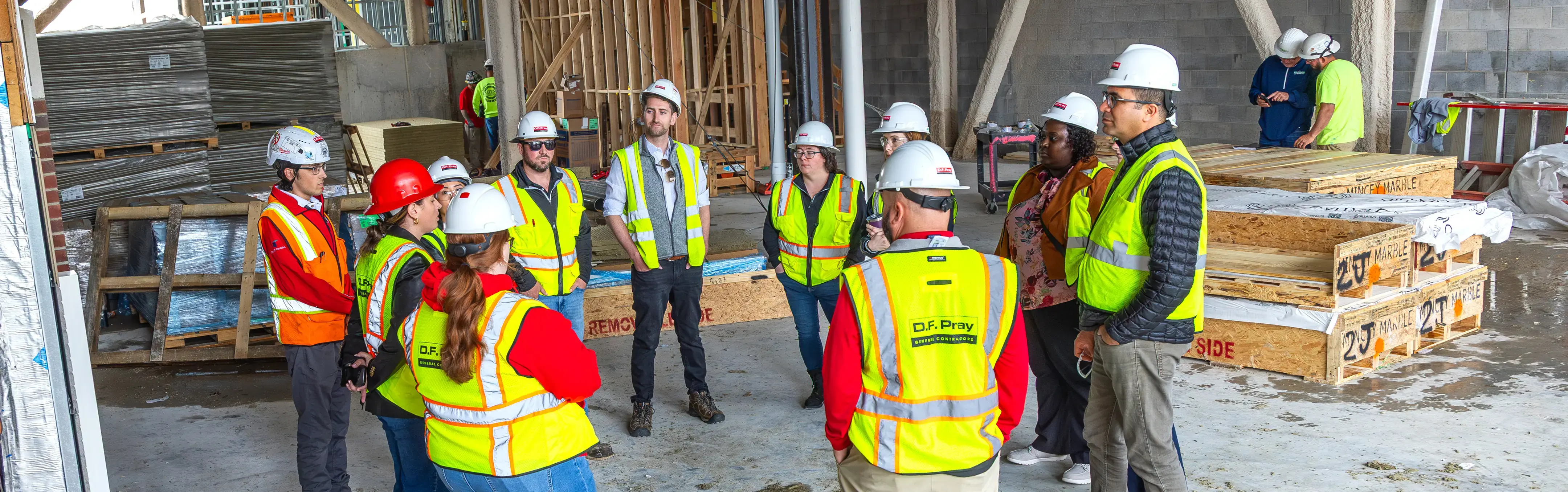 A construction site manager confers with the crew on a job site
