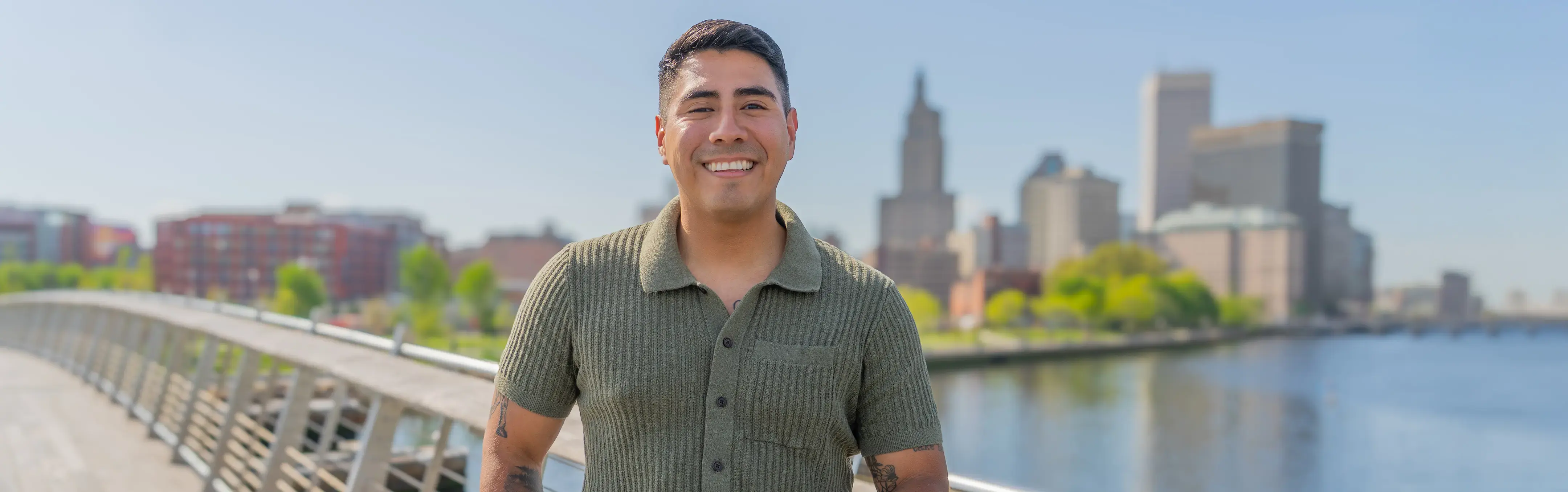 A criminal justice major poses for a photo infront of a city skyline