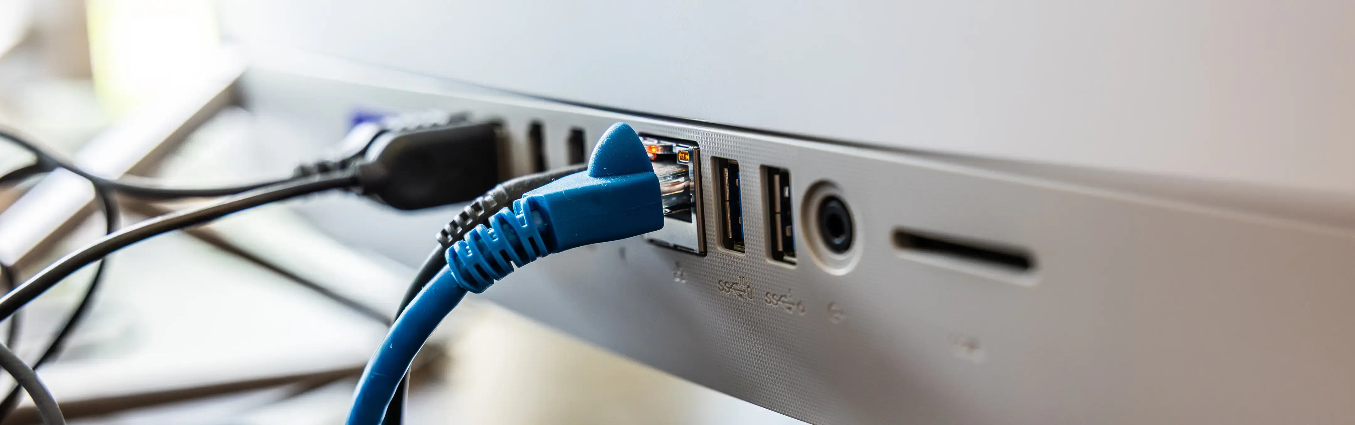 An ethernet cable plugged into the back of a computer