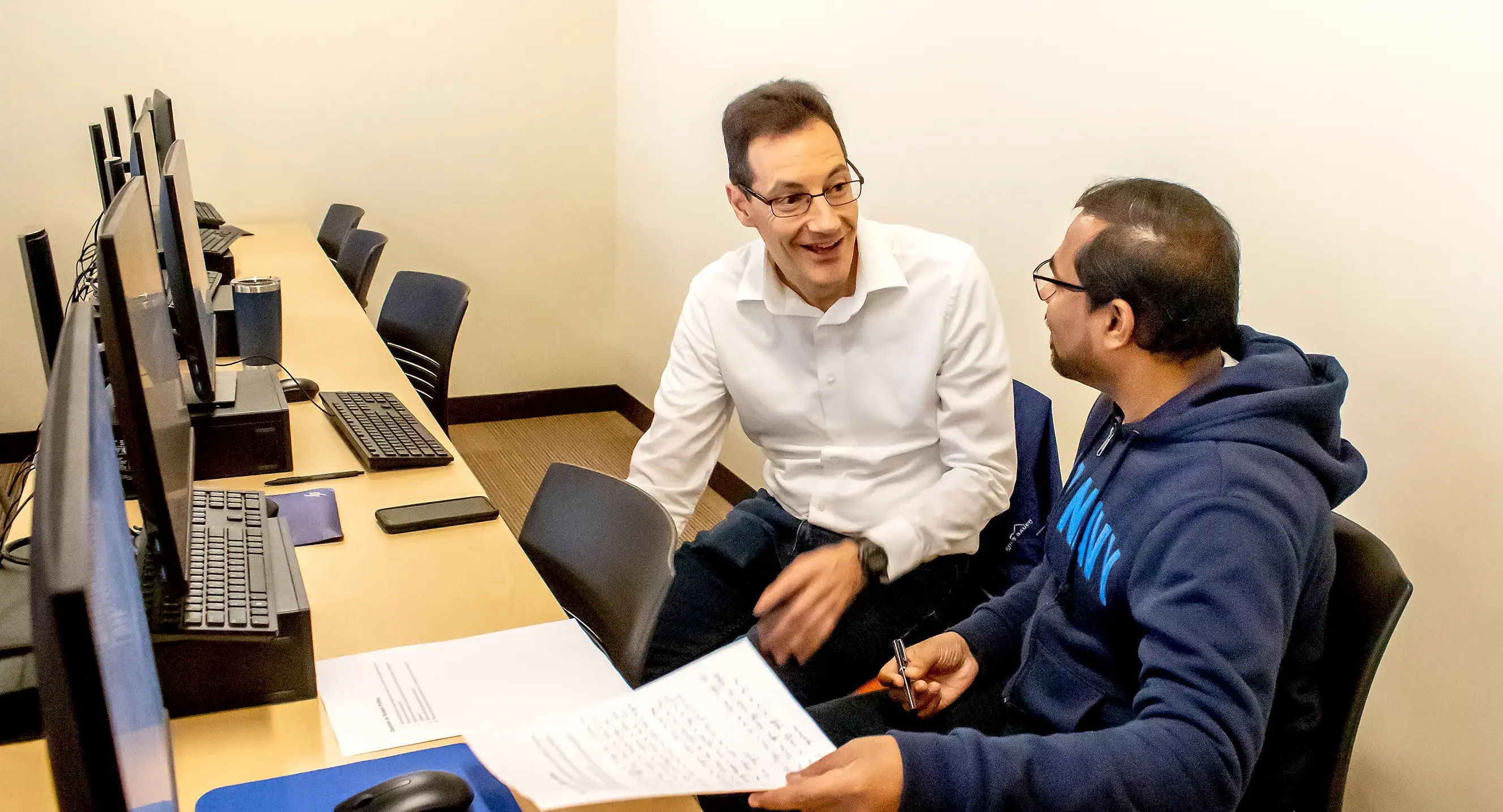A professor and student communicate during class on an assignment