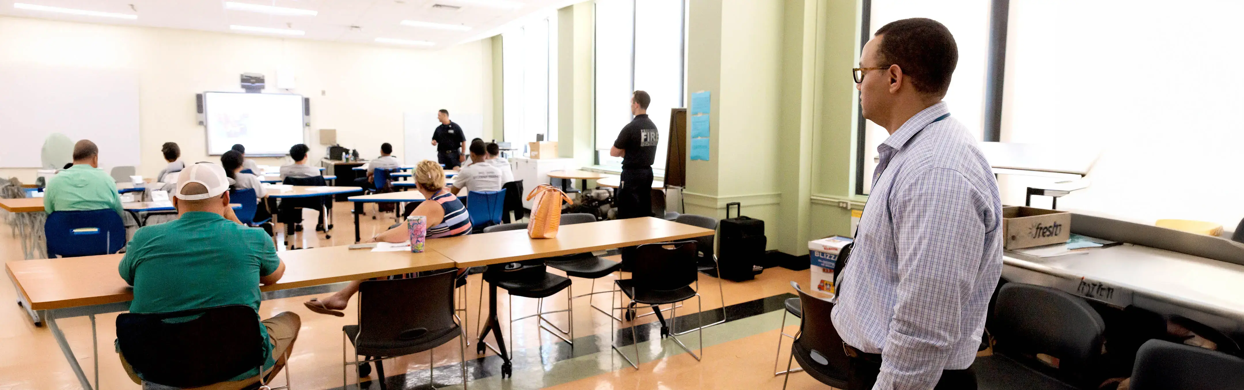 A man stands in the back of a room full of city employees