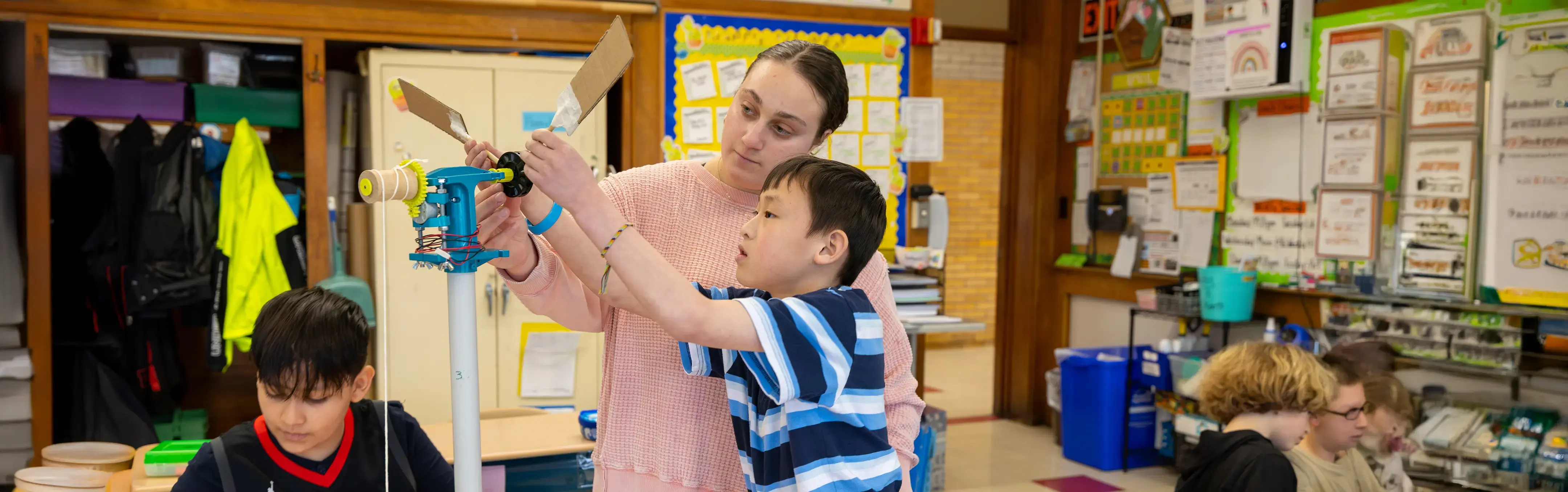 A teacher works with a student in a STEM classroom