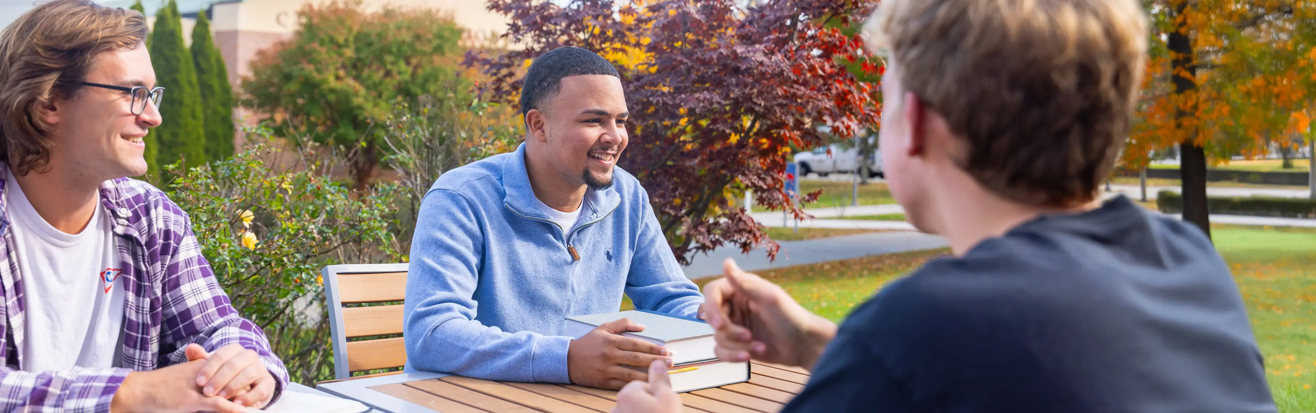 Students share a light-hearted moment while studying outside