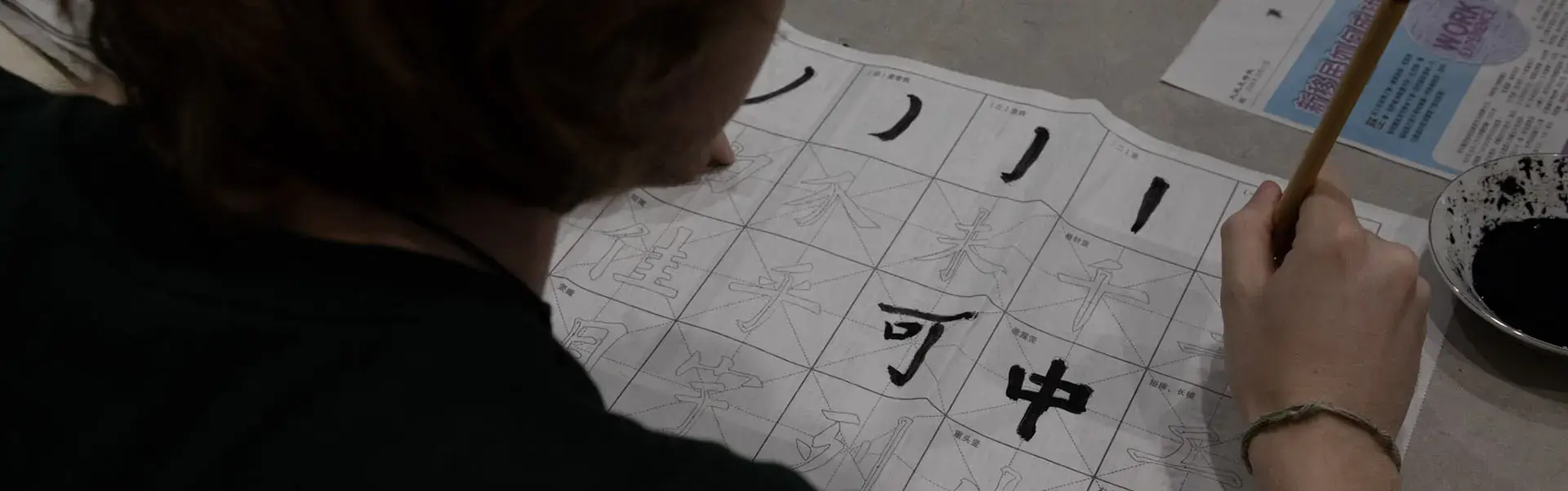 A student practices Chinese calligraphy