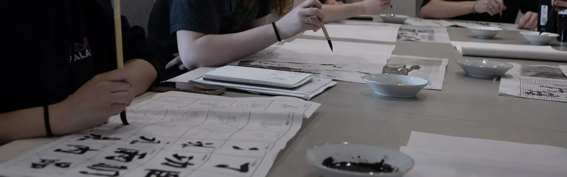 Students practice Chinese calligraphy